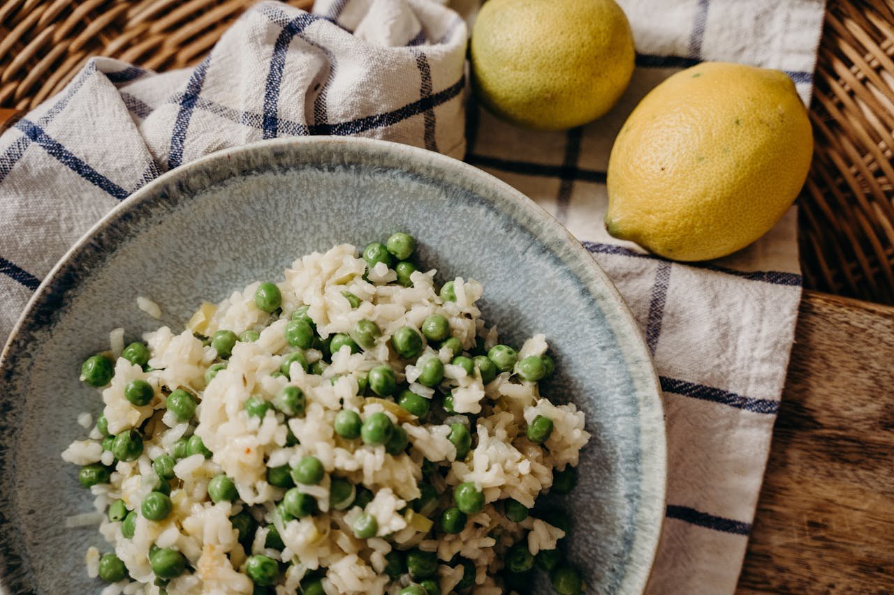 Close-up of a tasty pea risotto served with ripe lemons, highlighting the rich Italian flavors.